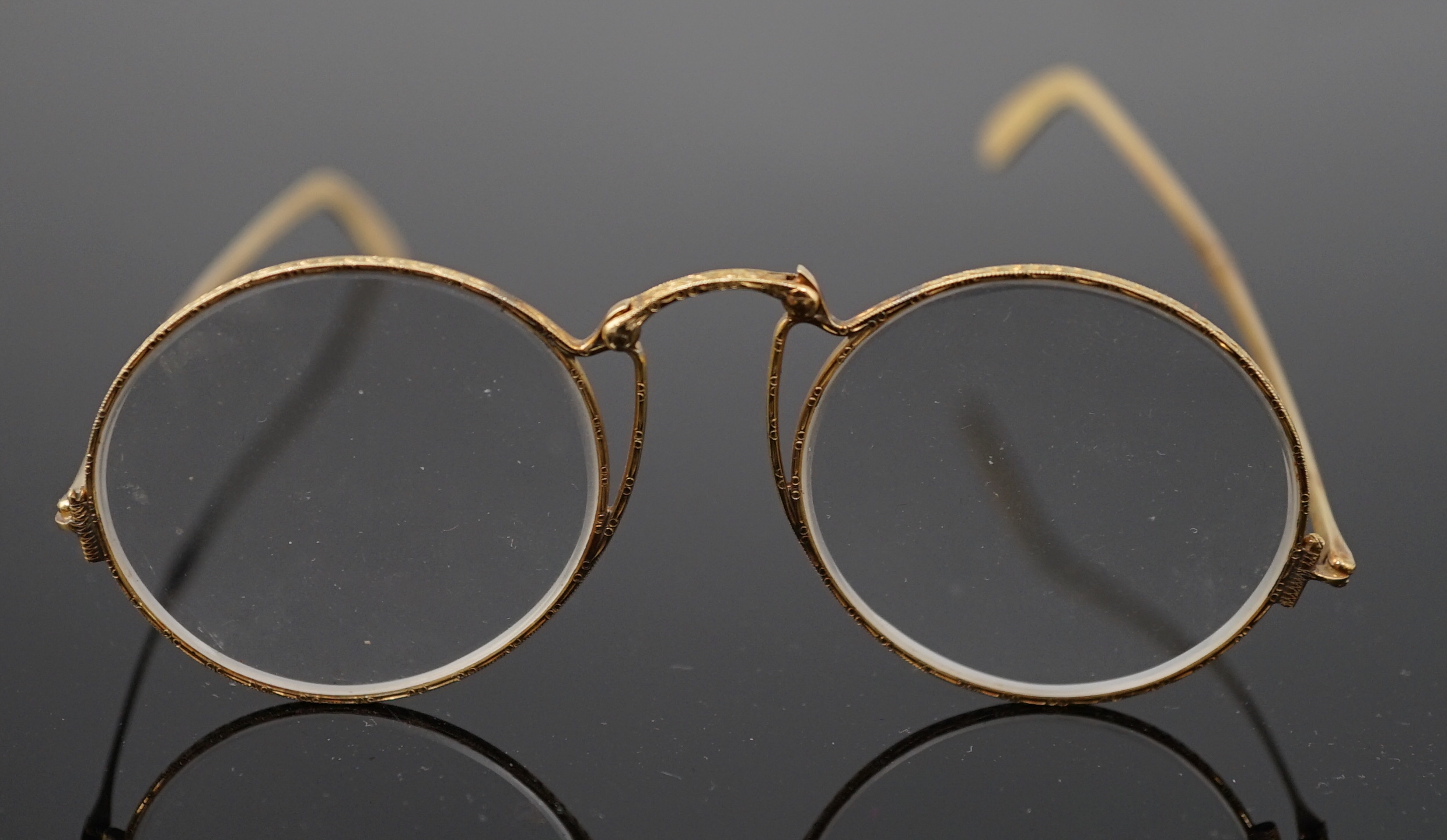 A pair of engraved gold mounted spectacles